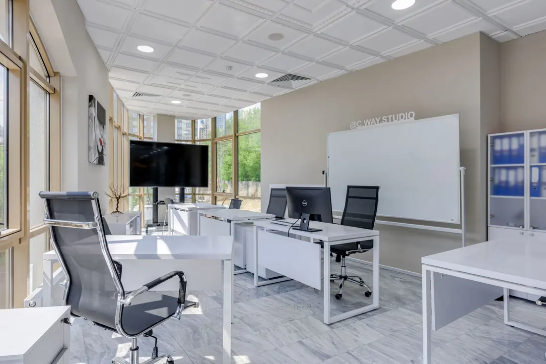 Bright office fit-out with white desks, mesh chairs and floor-to-ceiling windows